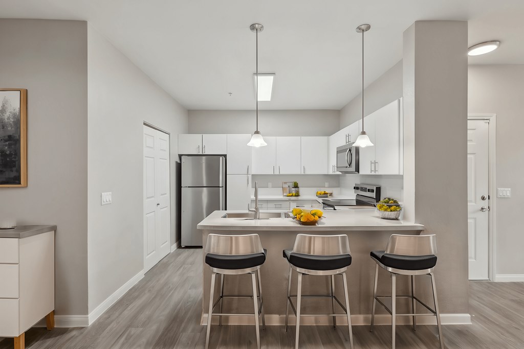 A modern kitchen with a bar stool at the island.