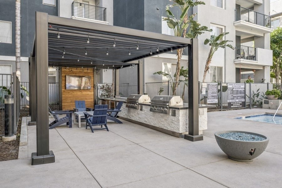 a patio with a pool and chairs and a pergola