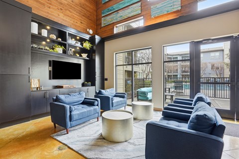 A modern living room with a dark blue couch and a wooden floor.