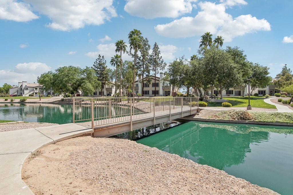 A bridge over a greenish body of water with a sandy shore.