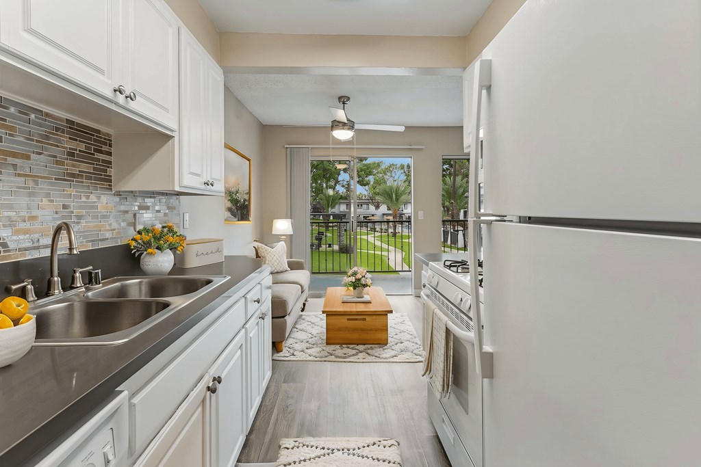 A kitchen with white cabinets and a white refrigerator.