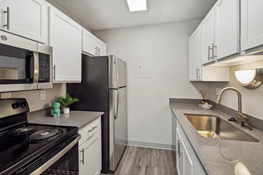 a kitchen with stainless steel appliances and white cabinets