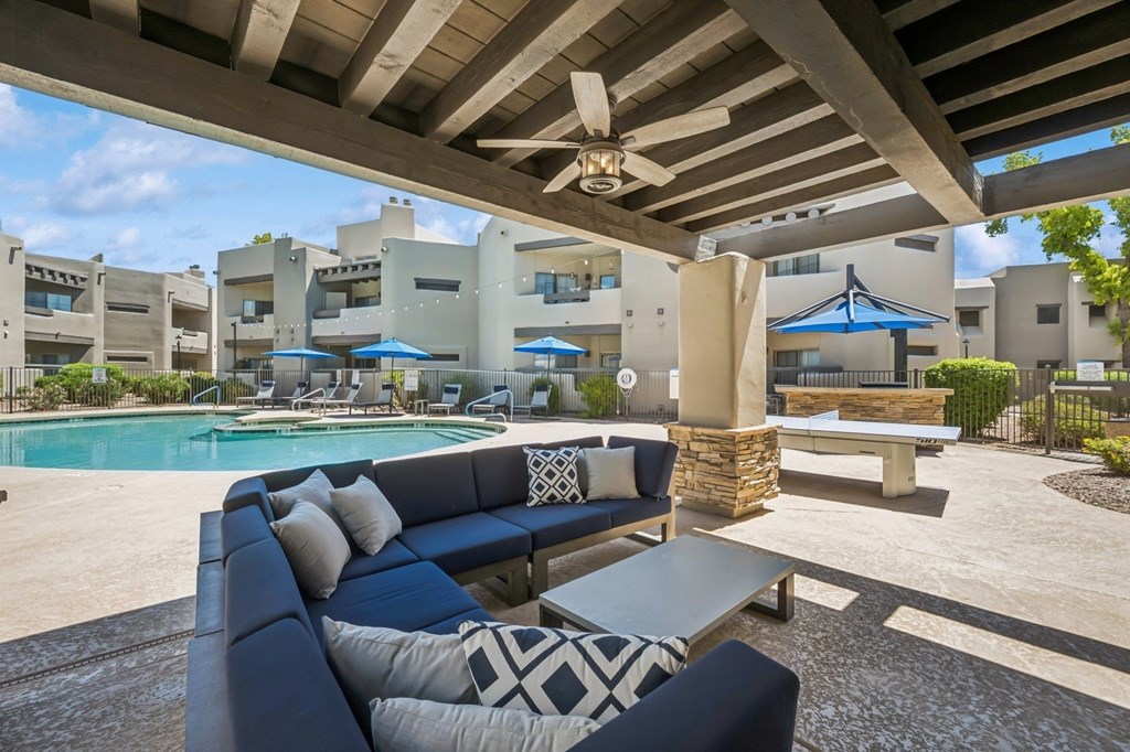 A patio with a pool and a blue couch.