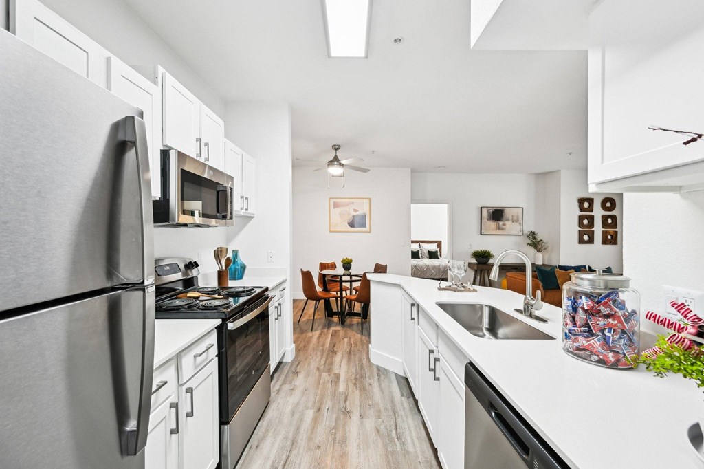 A kitchen with black appliances and white cabinets.