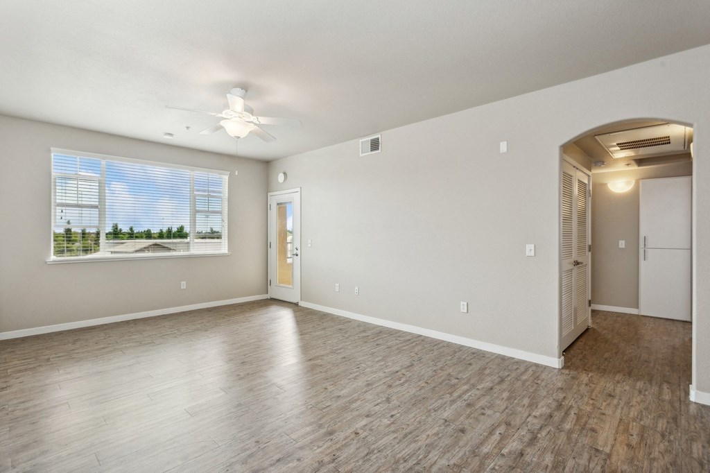 the living room of an empty house with a large window