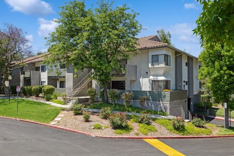 the view of an apartment building with trees and landscaping