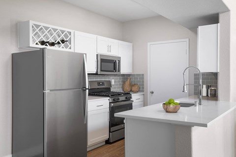 a kitchen with stainless steel appliances and a white counter top