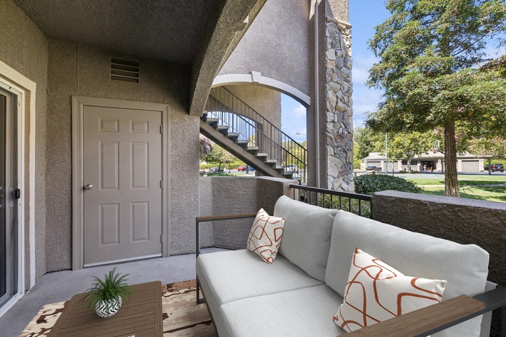 a patio with a couch and a table and a door