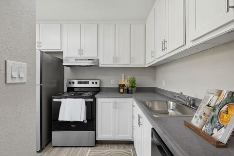 a white kitchen with stainless steel appliances and white cabinets
