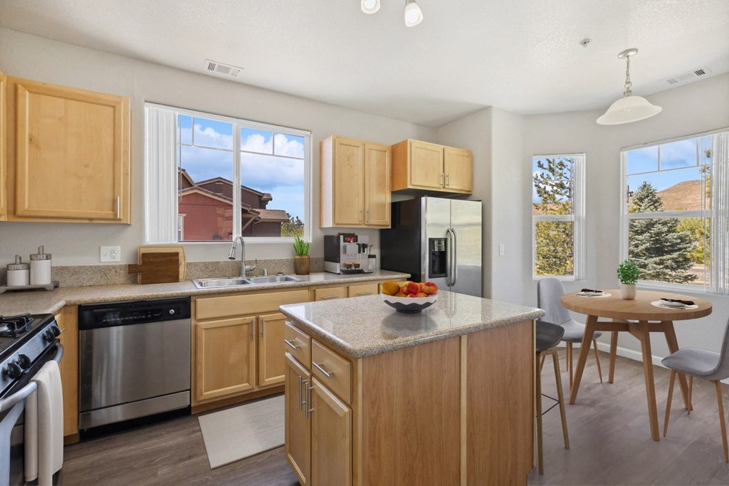 a kitchen with wooden cabinets and a table with a bowl of fruit