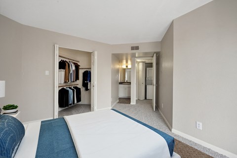 a bedroom with a large bed and a closet with clothes racks