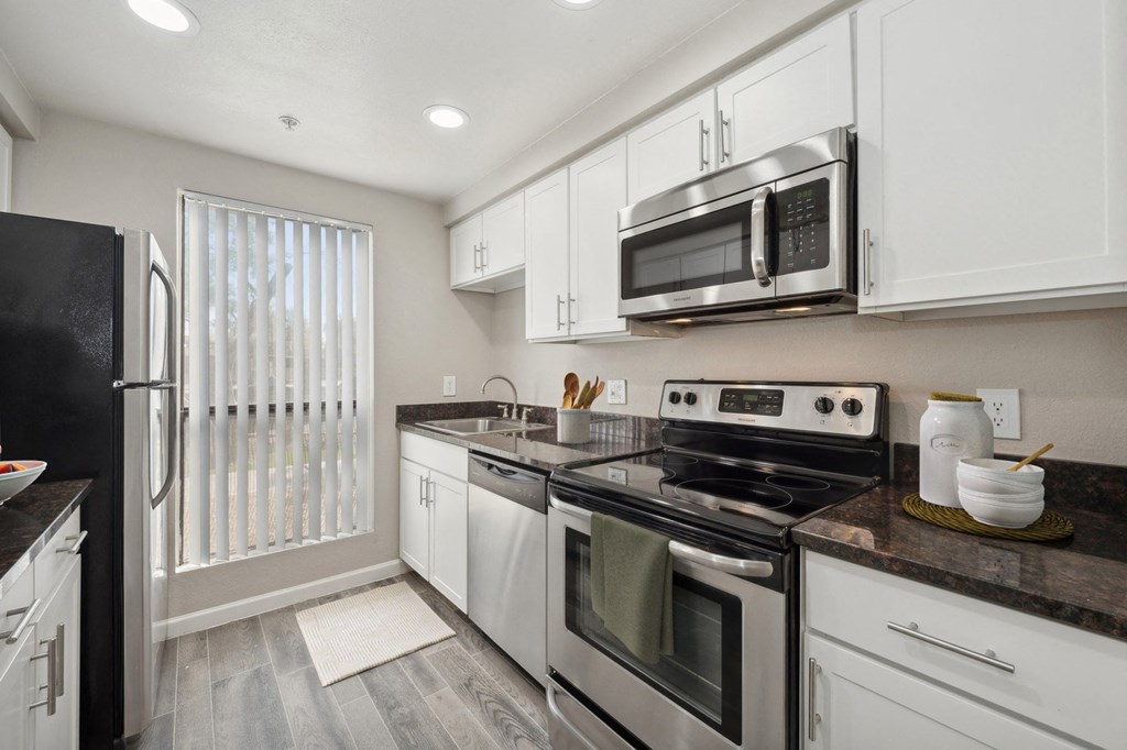 a kitchen with white cabinets and stainless steel appliances
