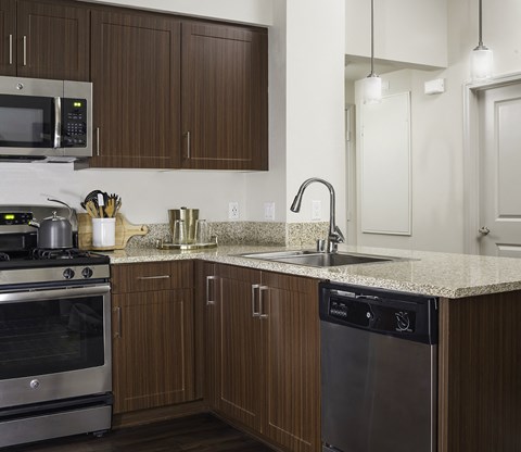 A kitchen with brown cabinets and a granite countertop.