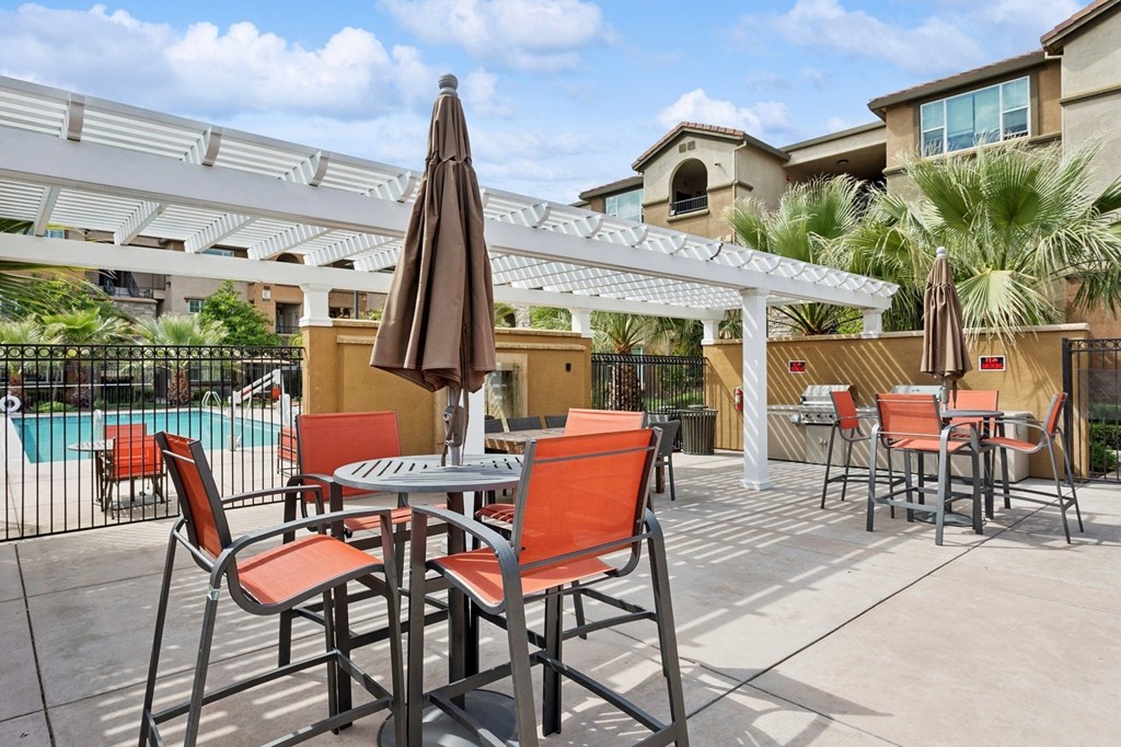 a patio with tables and chairs and a pool