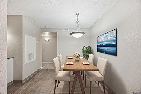 A dining room with a wooden table and chairs.