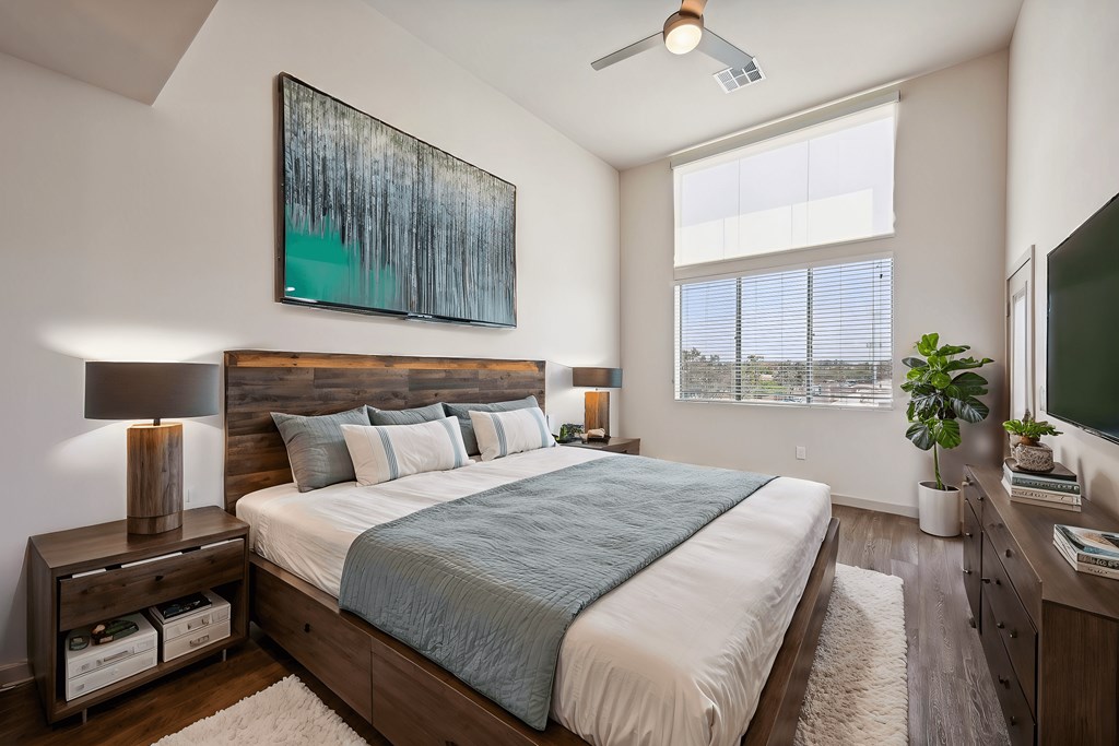 A bedroom with a large bed and a painting above it.