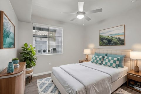 A bedroom with a large bed and a ceiling fan.