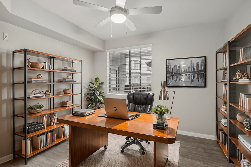 A room with a desk, chair, and shelves filled with items.