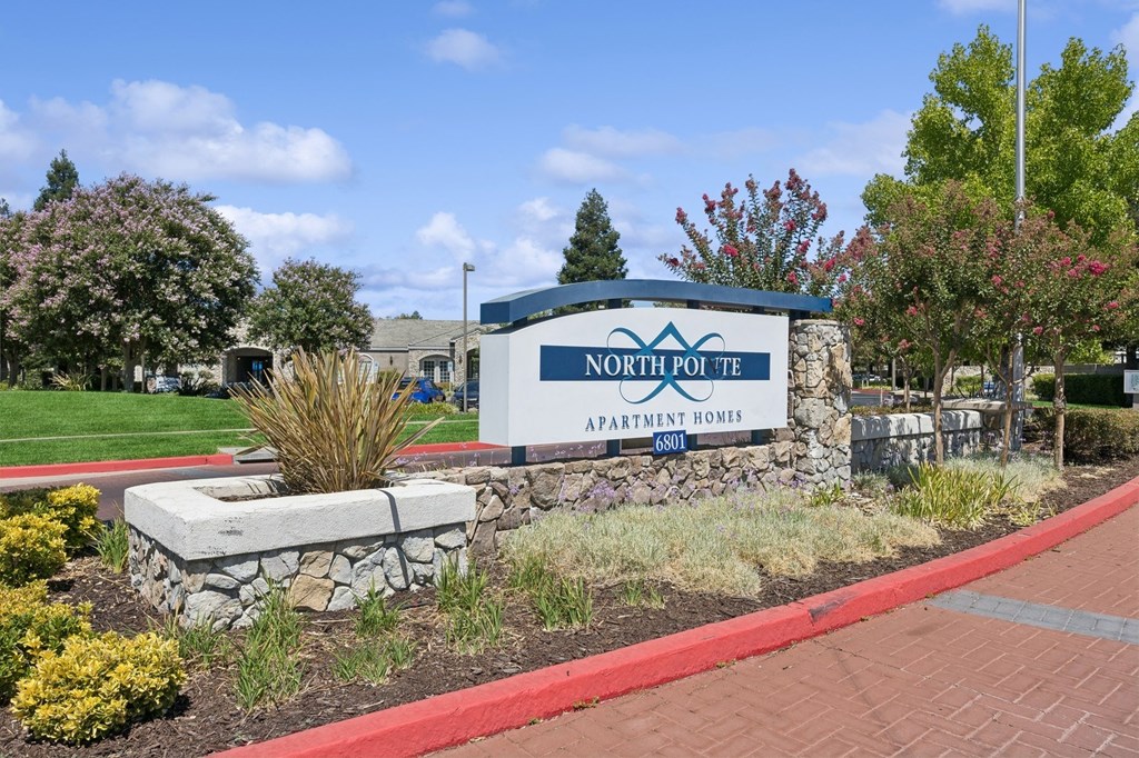 the sign in front of a brick sidewalk and grass