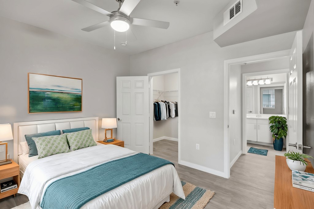 A bedroom with a large bed and a painting on the wall.