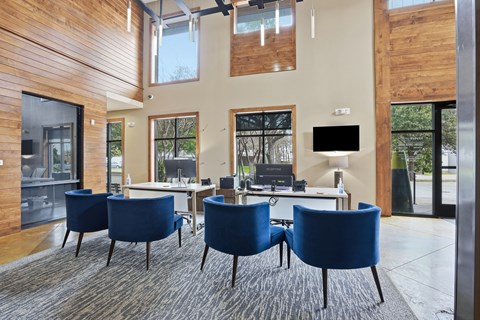 A conference room with blue chairs and a wooden wall.