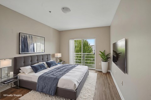 A bedroom with a large bed and a flat screen TV mounted on the wall.