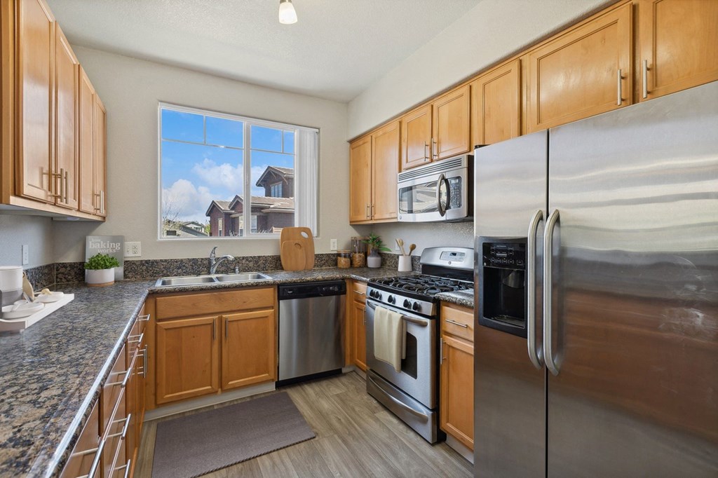 a kitchen with stainless steel appliances and wooden cabinets