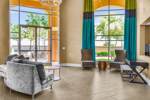 a living room with couches and chairs and large windows