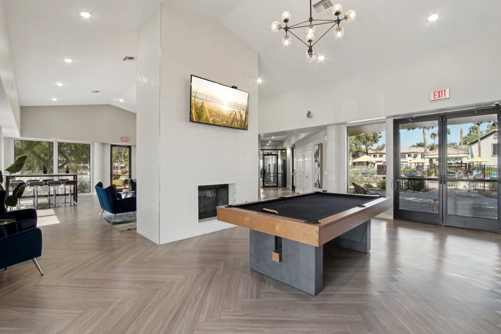 A room with a pool table and a fireplace.