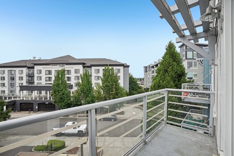 A view of a courtyard with a building in the background and a white van parked in the foreground.