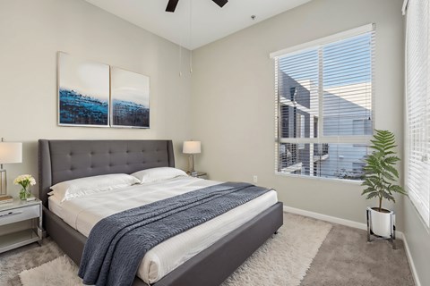 A bedroom with a large bed and a ceiling fan.