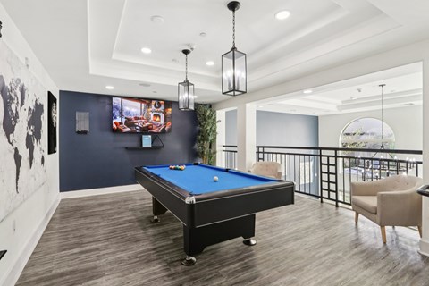 A pool table in a room with a balcony.