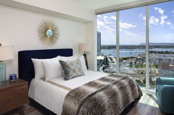 A bedroom with a large bed and a view of the city.