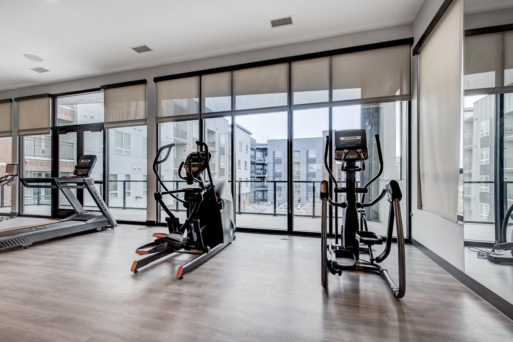a gym with floor to ceiling windows and exercise equipment