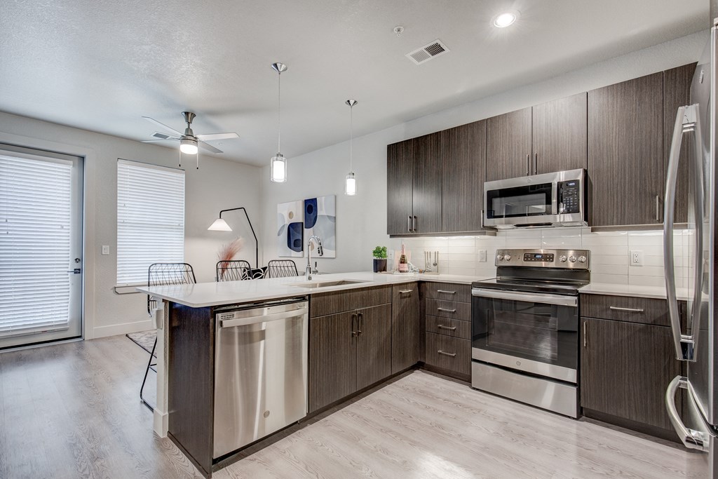 an open kitchen with stainless steel appliances and wooden cabinets