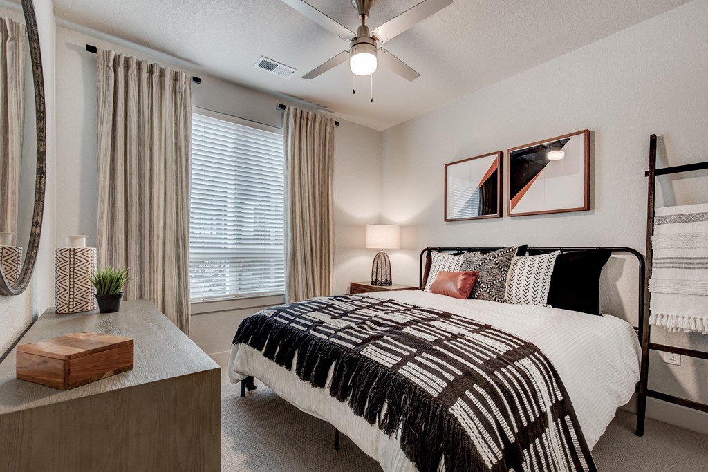our apartments offer a bedroom with a large bed and a ceiling fan