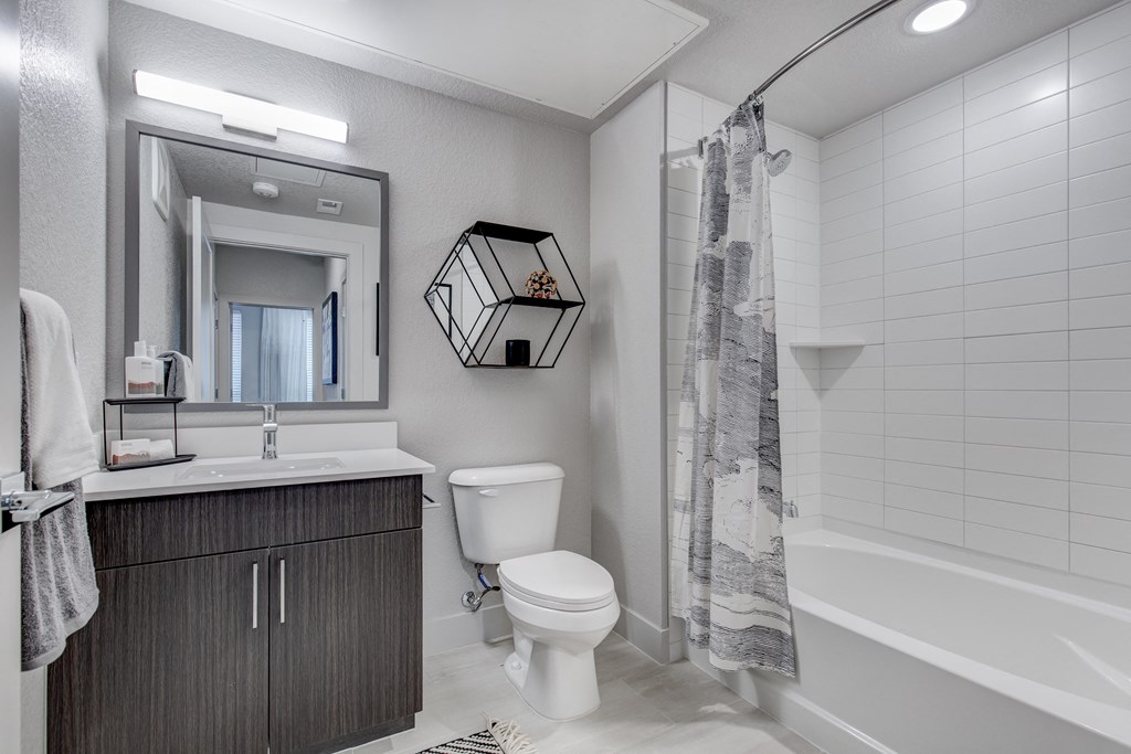 a bathroom with a toilet and a shower and a sink