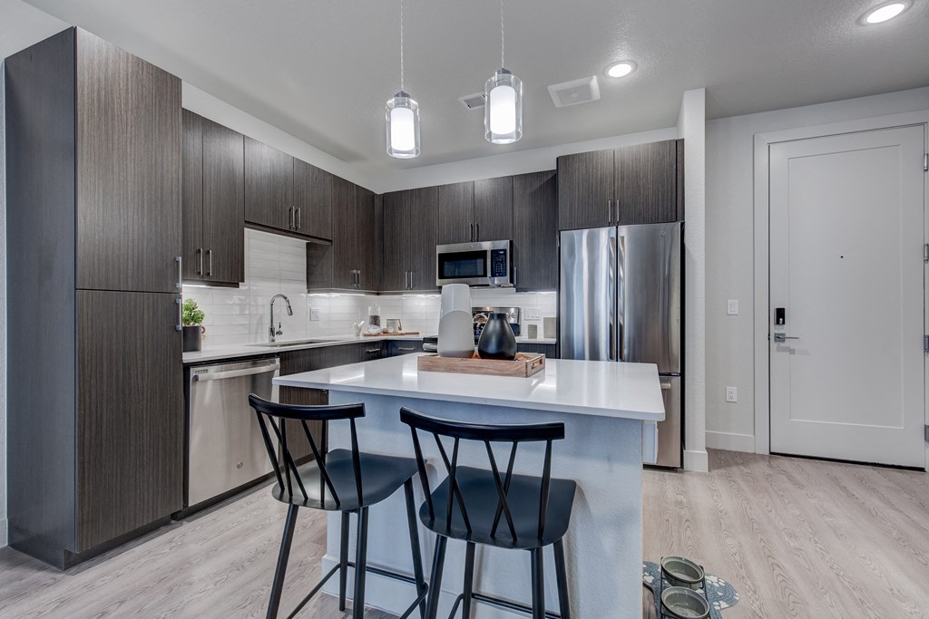 a kitchen with a large island with three stools