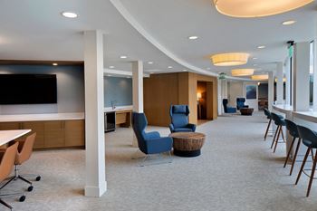A conference room with a television, chairs, and a table.