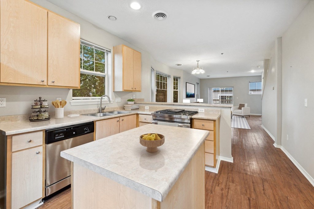 a large kitchen with an island with a bowl of fruit