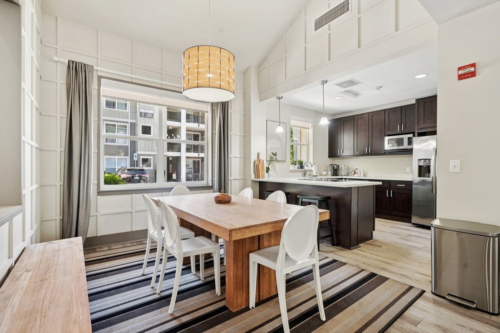 A modern kitchen with a dining table and chairs.