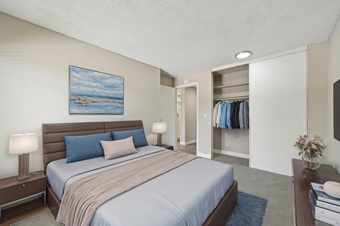 A bedroom with a large bed and a painting on the wall.