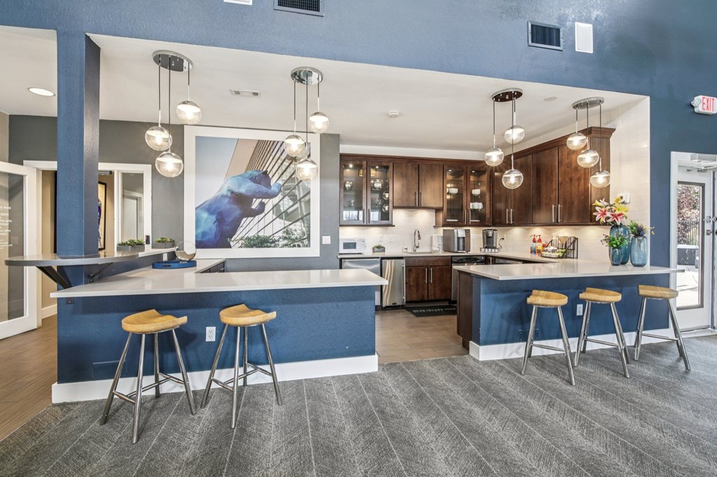 A kitchen with a blue counter and bar stools.