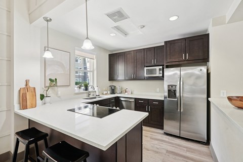 A modern kitchen with a white countertop and stainless steel appliances.