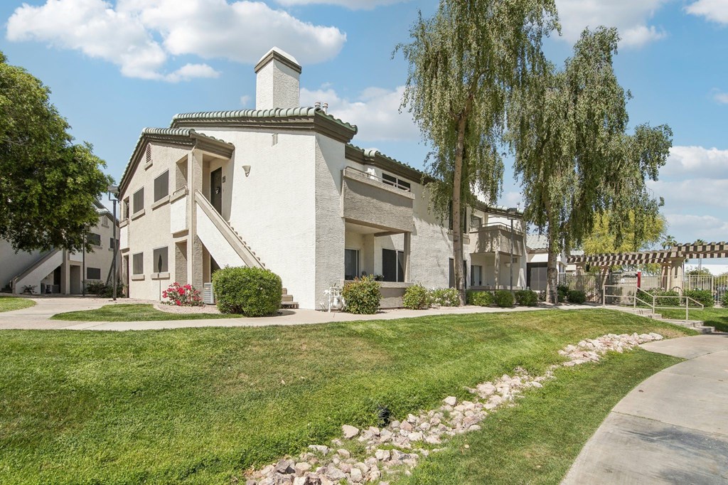 A white house with a green lawn in front.