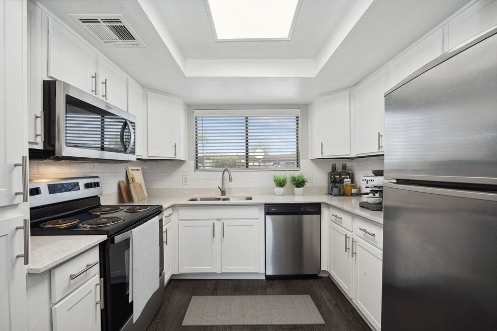 a kitchen with white cabinets and stainless steel appliances