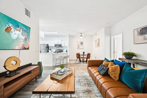 A living room with a brown leather couch and a wooden coffee table.