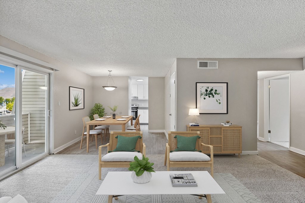 an open living room and dining room with a sliding glass door to a balcony