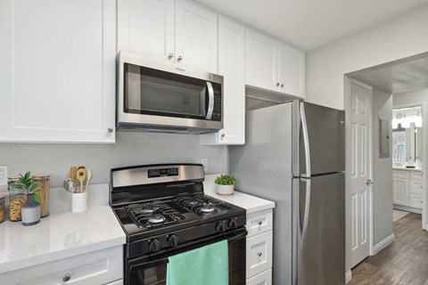 a kitchen with stainless steel appliances and white cabinets