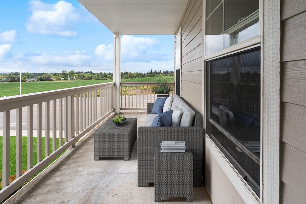 a covered porch with a couch and chairs and a tv